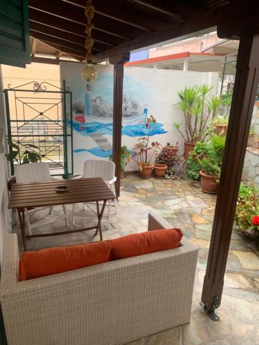 a patio with a couch and a table and a mural at Casa di Porto in Neos Marmaras
