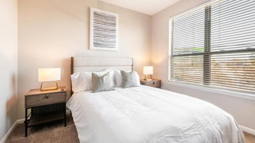 una camera bianca con un letto e due comodini di Landing Modern Apartment with Amazing Amenities (ID7989X60) a Greenville