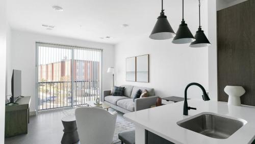 a white kitchen and living room with a couch at Landing Modern Apartment with Amazing Amenities (ID1791X13) in Richmond