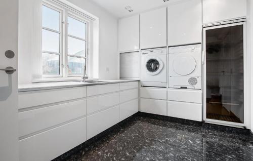 a white laundry room with a washer and dryer at Amazing Home In Blokhus With Kitchen in Blokhus