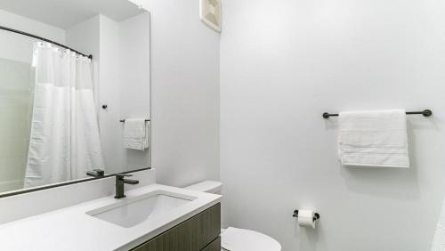 uma casa de banho branca com um lavatório e um espelho em Landing Modern Apartment with Amazing Amenities (ID1791X15) em Richmond