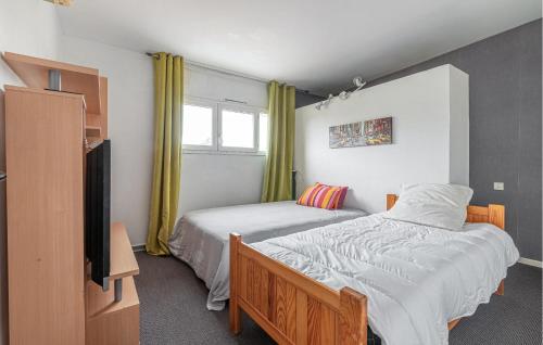 1 dormitorio con 2 camas y TV. en Beautiful Home In Caissargues With Outdoor Swimming Pool, en Caissargues