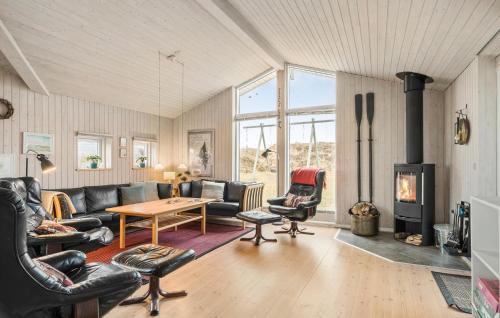a living room with leather furniture and a wood stove at Holiday Home Henriettevej Hvide Sande Ix in Bjerregård