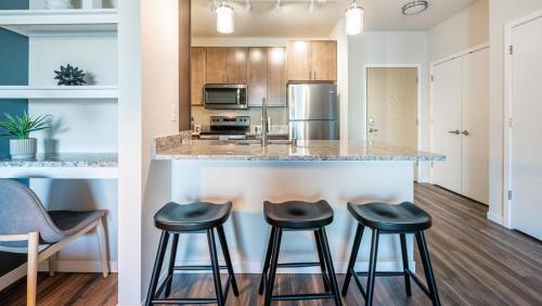 a kitchen with a counter and stools at a bar at Landing Modern Apartment with Amazing Amenities (ID1800X46) in Birmingham