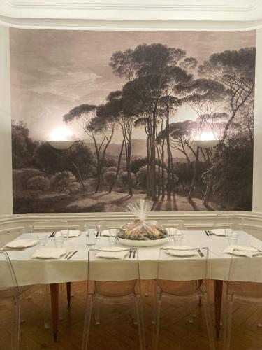 une table dans un restaurant avec une peinture sur le mur dans l'établissement Les Trois Chérubins centre Dieppe plage terrasse parking privatif, à Dieppe