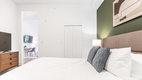 邁爾斯堡的住宿－Landing Modern Apartment with Amazing Amenities (ID7569X13)，卧室配有白色的床和电视。