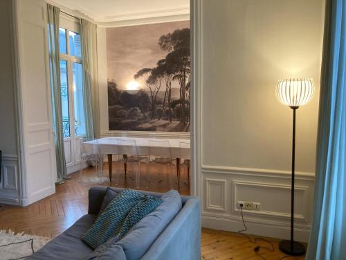 un salon avec un canapé et un tableau au mur dans l'établissement Les Trois Chérubins centre Dieppe plage terrasse parking privatif, à Dieppe