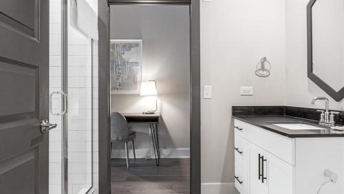 Landing Modern Apartment with Amazing Amenities (ID1208X667) في ديكاتور: حمام أبيض مع حوض ومكتب