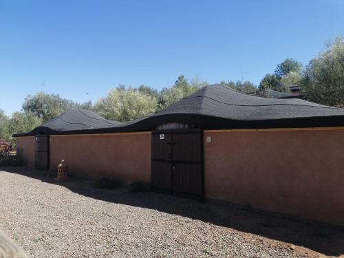a brown building with a black roof at Terres d'Amanar in Tahannout