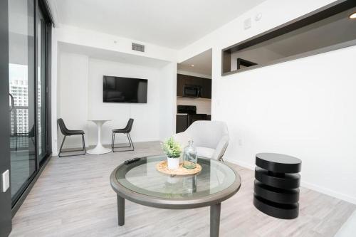 sala de estar con mesa de cristal y sillas en Landing Modern Apartment with Amazing Amenities (ID1398X788), en Fort Lauderdale