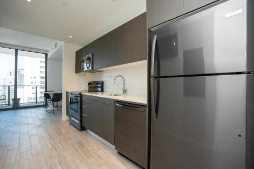 uma cozinha com um frigorífico de aço inoxidável em Landing Modern Apartment with Amazing Amenities (ID1398X788) em Fort Lauderdale