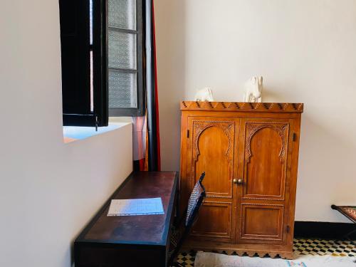 a room with a wooden cabinet and a wooden table at Riad New Moon in Marrakesh