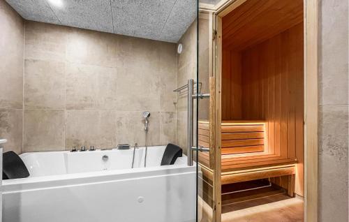 a bathroom with a white tub and a wooden door at 2 Bedroom Stunning Home In Harbore in Harboør
