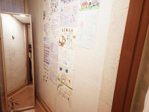 a wall covered with drawings and writing on a wall at Lydia Craft Guesthouse in Seoul