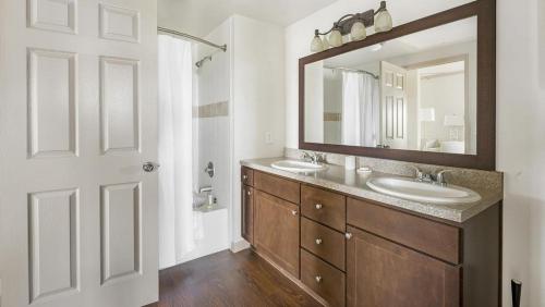 La salle de bains est pourvue de 2 lavabos et d'un grand miroir. dans l'établissement Landing Modern Apartment with Amazing Amenities (ID1192X865), à Houston