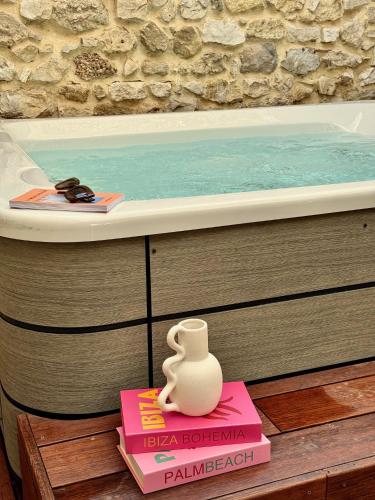 un vase posé sur un livre à côté d'une baignoire dans l'établissement Mas Revive, à Grabels