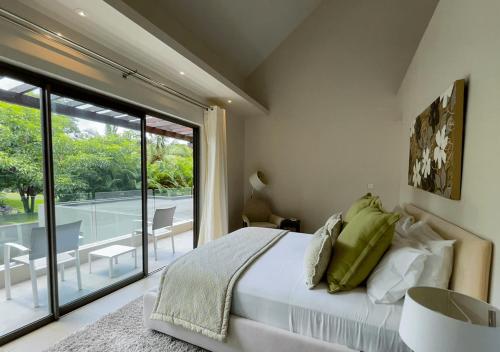 1 dormitorio con cama y vistas a un patio en Villa Fairways - Private, Golf & Luxe en Centre de Flacq