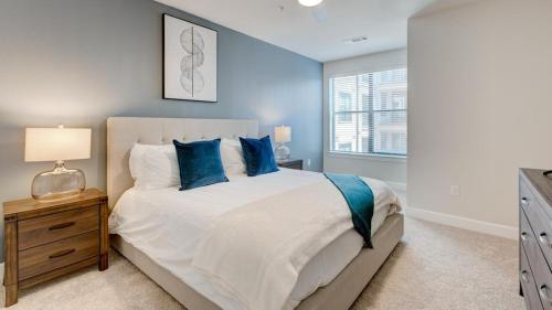 a bedroom with a large bed with blue pillows at Landing Modern Apartment with Amazing Amenities (ID3704X38) in Frisco