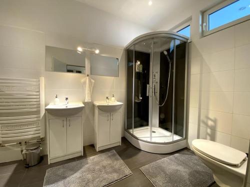 een badkamer met een douche, 2 wastafels en een toilet bij Wohnung im 15. Bezirk in Wenen