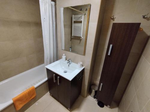 a bathroom with a sink and a mirror and a tub at Apartamento en la Torre Golf Resort in Torre-Pacheco