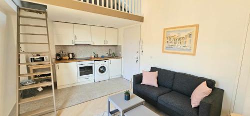un salon avec un canapé et une cuisine dans l'établissement Le Virenque, à Nice