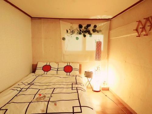 a bedroom with a bed and a window at Lydia Craft Guesthouse in Seoul