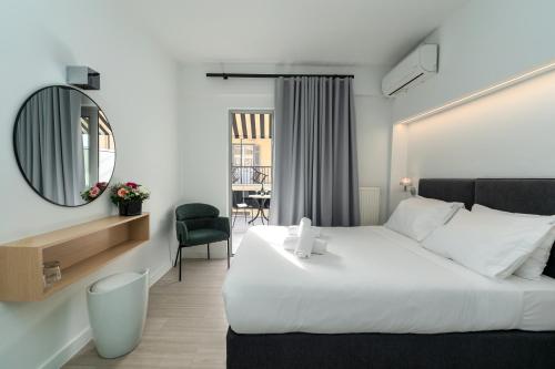 Habitación de hotel con cama grande y espejo en Hotel Adonis Athens en Atenas