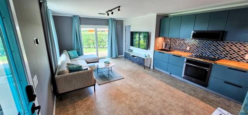 cocina con armarios azules y sala de estar. en Luxury beach villa in paradise. en Treasure Cay