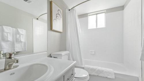uma casa de banho branca com um lavatório e um WC em Landing Modern Apartment with Amazing Amenities (ID1232X656) em Las Vegas