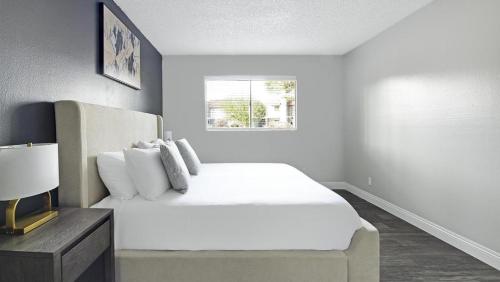 um quarto branco com uma cama e uma janela em Landing Modern Apartment with Amazing Amenities (ID1232X656) em Las Vegas