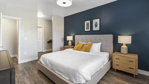 um quarto com uma cama grande e uma parede azul em Landing Modern Apartment with Amazing Amenities (ID4626X4) em Salt Lake City