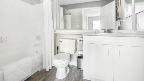uma casa de banho branca com um WC e um lavatório em Landing Modern Apartment with Amazing Amenities (ID9155X81) em Durham