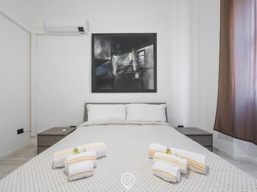 a bedroom with a bed with three pillows on it at Port View Apartment in Cagliari