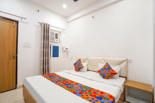 - une chambre dotée d'un lit avec des oreillers colorés dans l'établissement FabHotel SK Residency, à Varanasi