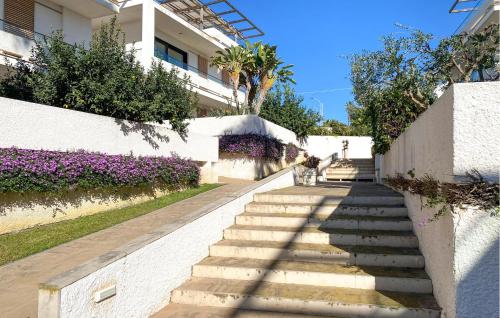 eine Treppe, die zu einem Gebäude mit lila Blumen führt in der Unterkunft 2 Bedroom Cozy Home In Marina Di Ragusa in Marina di Ragusa