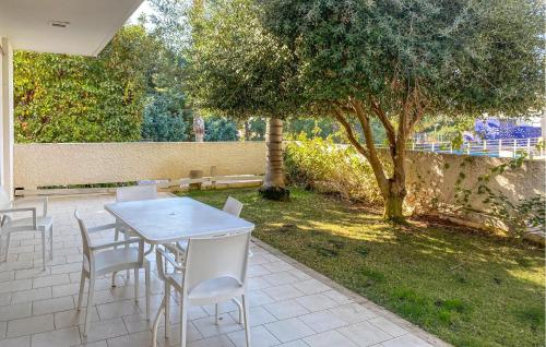 einen Tisch und Stühle auf einer Terrasse mit einem Baum in der Unterkunft 2 Bedroom Cozy Home In Marina Di Ragusa in Marina di Ragusa
