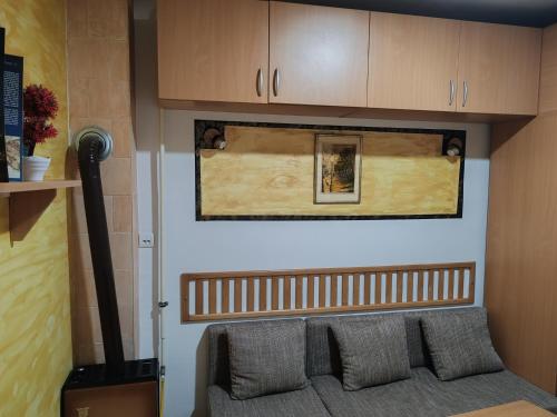 ein Wohnzimmer mit einem Sofa und Holzschränken in der Unterkunft Sobica in Sremska Kamenica