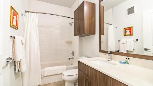 uma casa de banho branca com um lavatório e um WC em Landing Modern Apartment with Amazing Amenities (ID1954) em Aurora