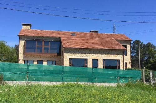 a house with a green fence in front of it at 4 bedrooms house with private pool jacuzzi and wifi at Roxos in Santiago de Compostela