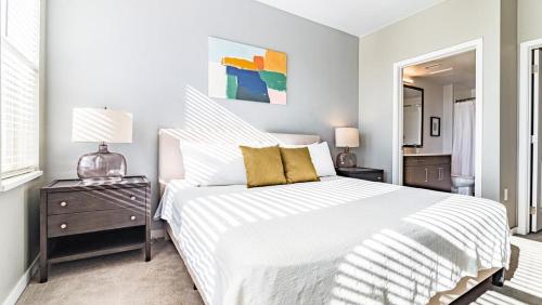 um quarto com uma grande cama branca e uma mesa de cabeceira em Landing Modern Apartment with Amazing Amenities (ID1954) em Aurora