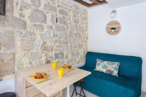 une table avec deux assiettes de nourriture et un canapé bleu dans l'établissement Cozy boutique apartment in the heart of Paris, à Paris