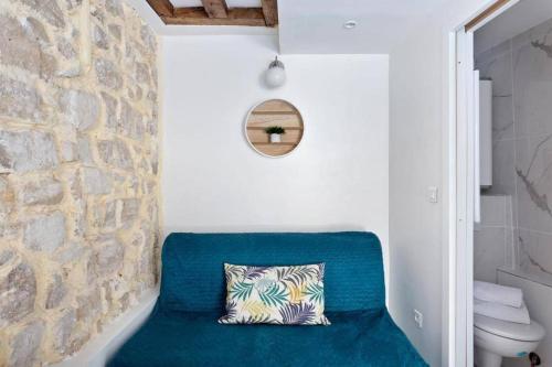 une chaise bleue avec un oreiller dans une salle de bain dans l'établissement Cozy boutique apartment in the heart of Paris, à Paris