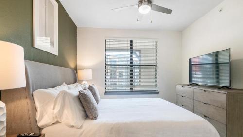 um quarto com uma cama branca e uma televisão em Landing Modern Apartment with Amazing Amenities (ID1172X300) em San Antonio
