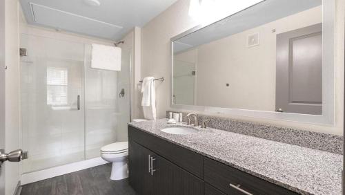 uma casa de banho com um lavatório, um WC e um espelho. em Landing Modern Apartment with Amazing Amenities (ID1172X300) em San Antonio