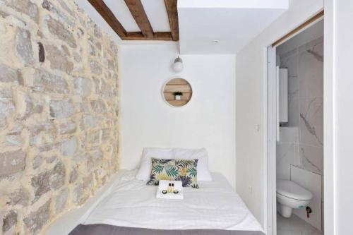 - une petite chambre avec un mur en pierre dans l'établissement Cozy boutique apartment in the heart of Paris, à Paris