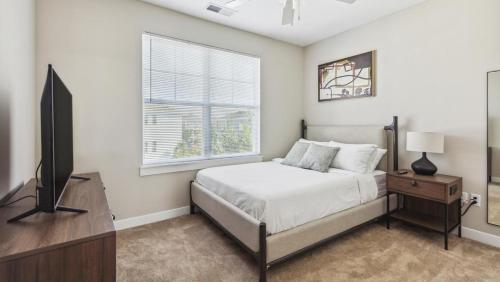 1 dormitorio con 1 cama, TV y ventana en Landing Modern Apartment with Amazing Amenities (ID8519X38), en Fishers