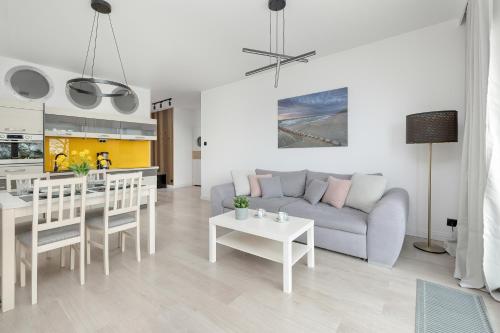 a living room with a couch and a table at Apartamenty Porta Mare by Renters in Dziwnówek