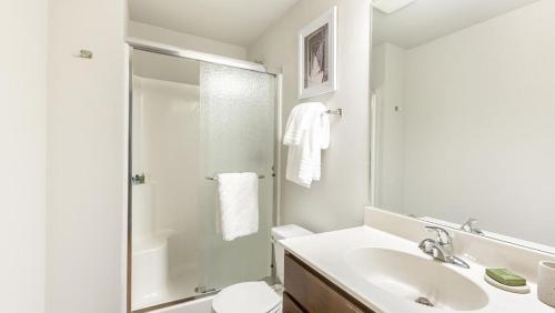a white bathroom with a sink and a shower at Landing Modern Apartment with Amazing Amenities (ID9106X83) in Omaha