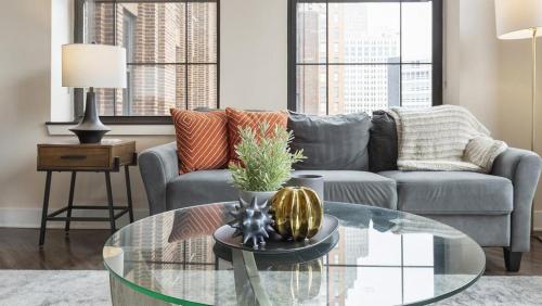 a living room with a couch and a glass table at Landing Modern Apartment with Amazing Amenities (ID1884X79) in Detroit