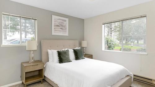1 dormitorio blanco con 1 cama y 2 ventanas en Landing Modern Apartment with Amazing Amenities (ID2236X76), en Kent